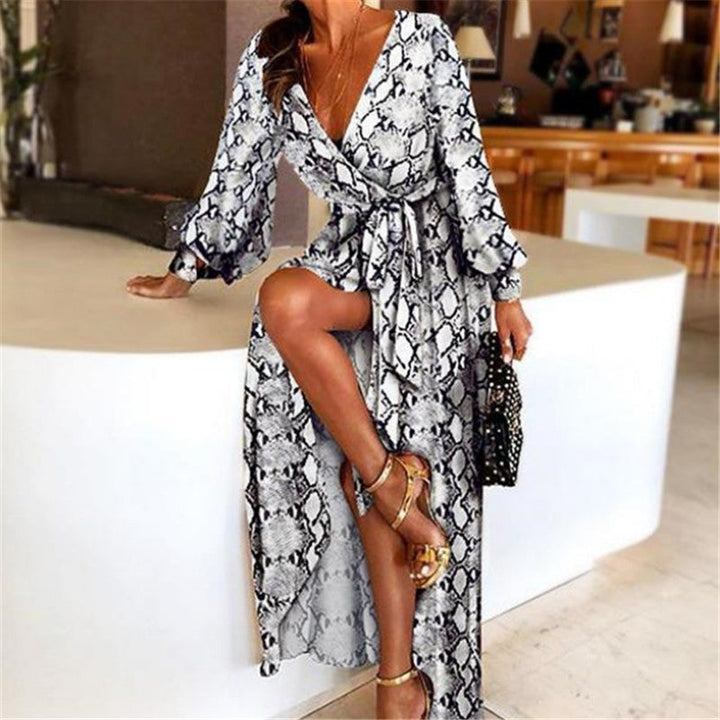 Woman at golden hour wearing the Tessa vintage print maxi dress with a waist belt and long statement sleeves.