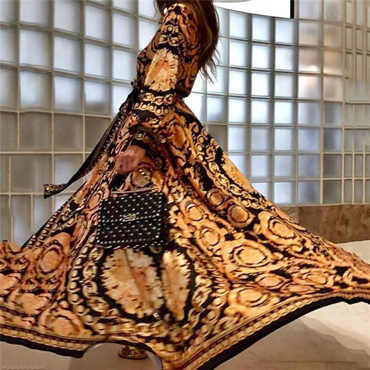 Woman at golden hour wearing the Tessa vintage print maxi dress with a waist belt and long statement sleeves.