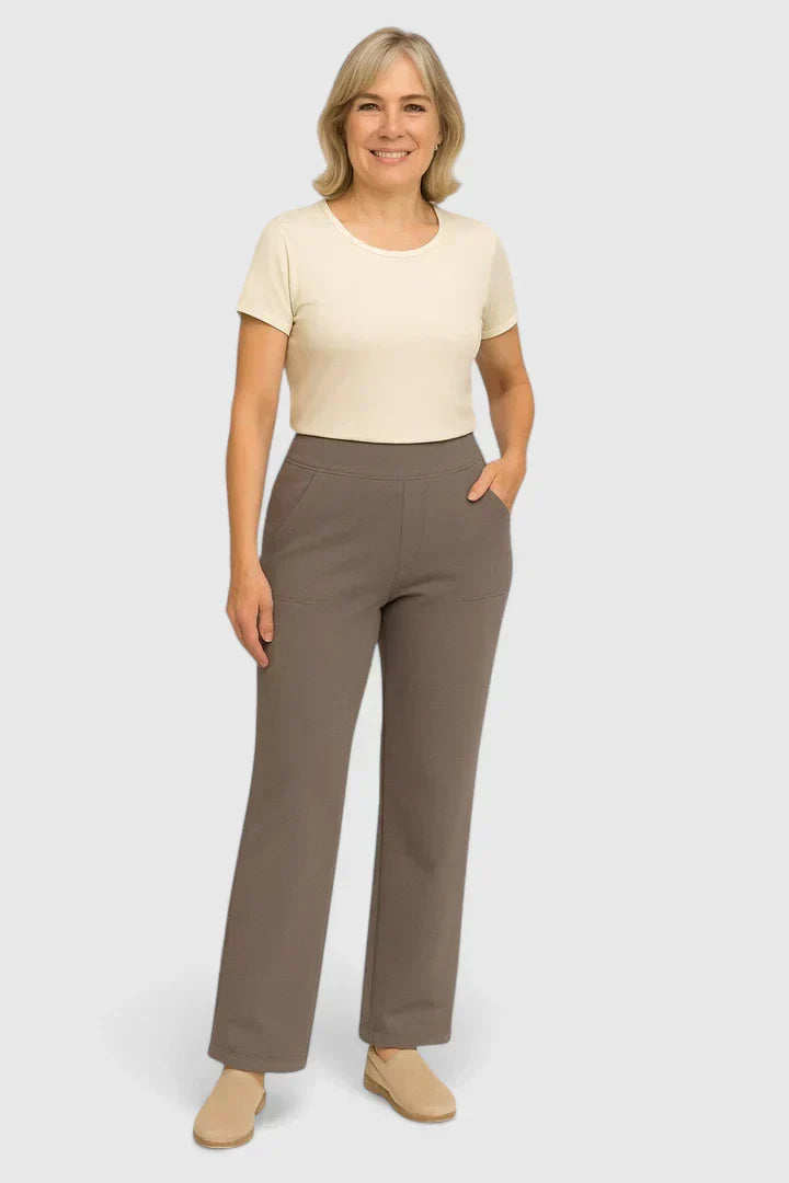 A woman in tailored trousers styled with a simple top for an elegant, comfortable everyday look.