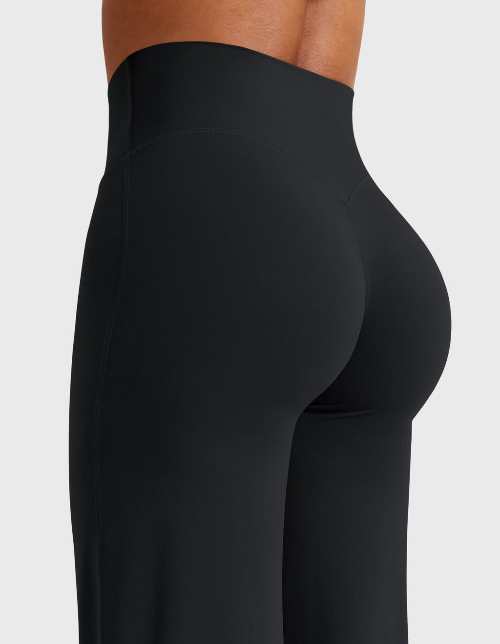 Black high-waisted power flare leggings with a contoured back seam and wide flared leg